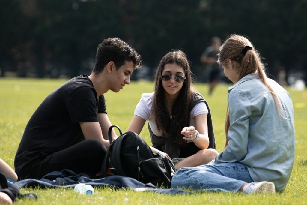 Estudiantes de Inter-Estades conversando sentados en el césped